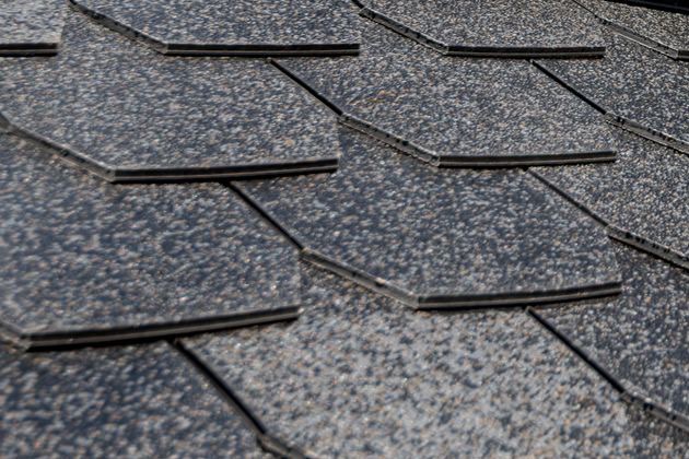 Mid-job: synthetic underlayment down, first bundles of architectural shingles being set