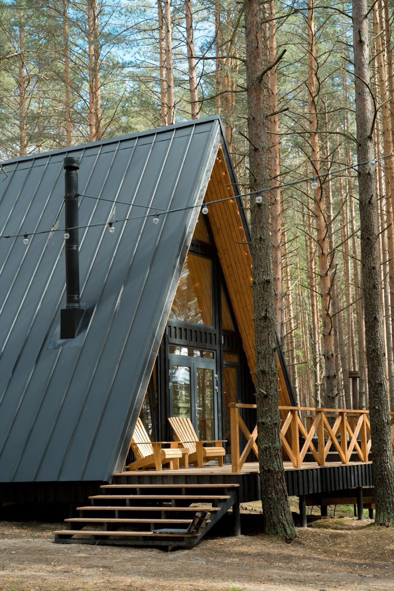 Standing seam metal roof on an A-frame cabin among pines